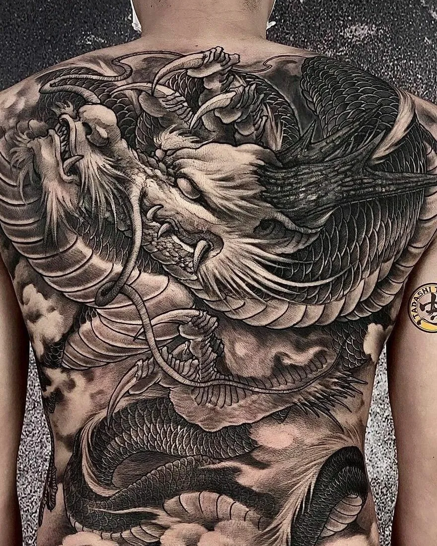 Detailed dragon tattoo covering a person's back, showcasing intricate scales and fierce expression.