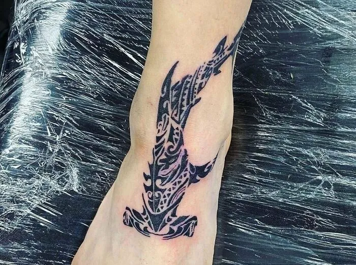 A tribal tattoo featuring intricate patterns on an ankle.