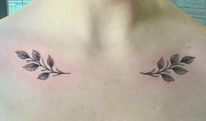 Floral branch collarbone tattoos on skin, minimalist design for both men and women.