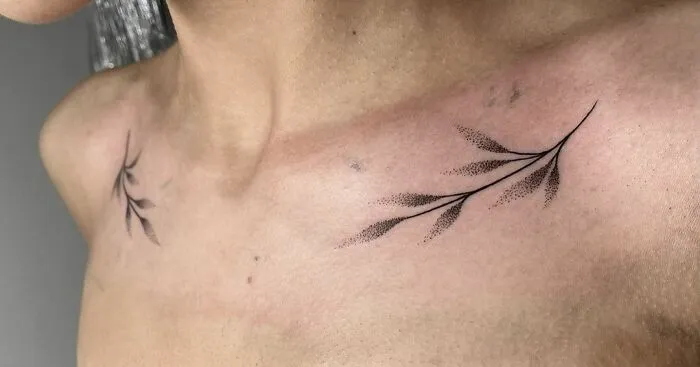 Minimalist collarbone tattoo design with delicate leaf branches.