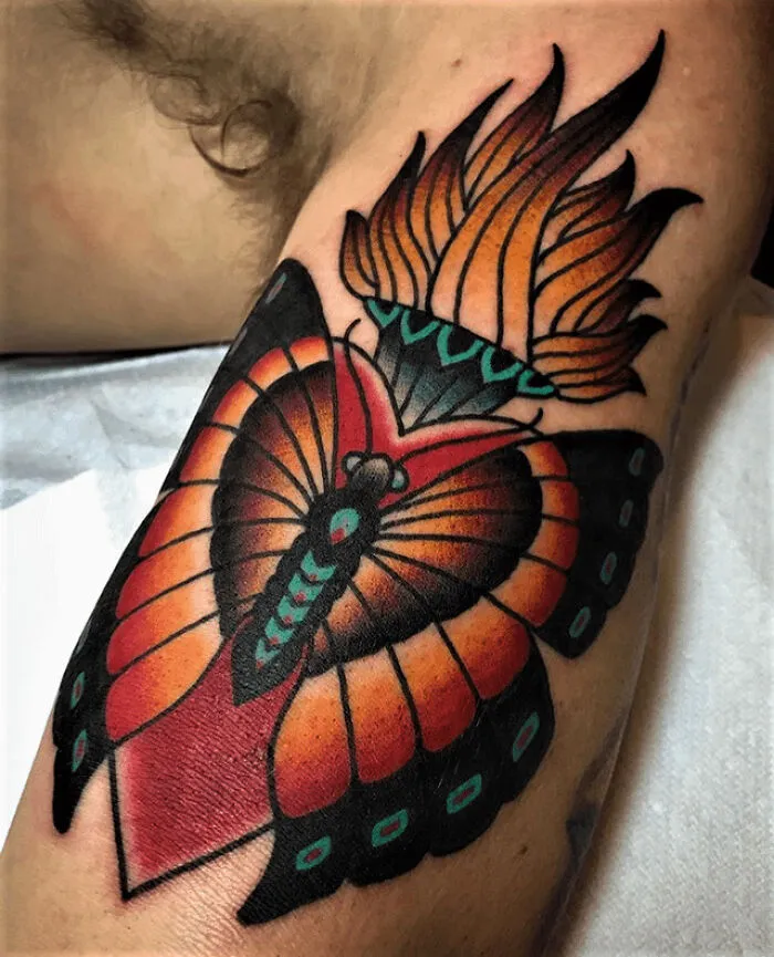 Colorful butterfly tattoo with vibrant wings and abstract flame design.