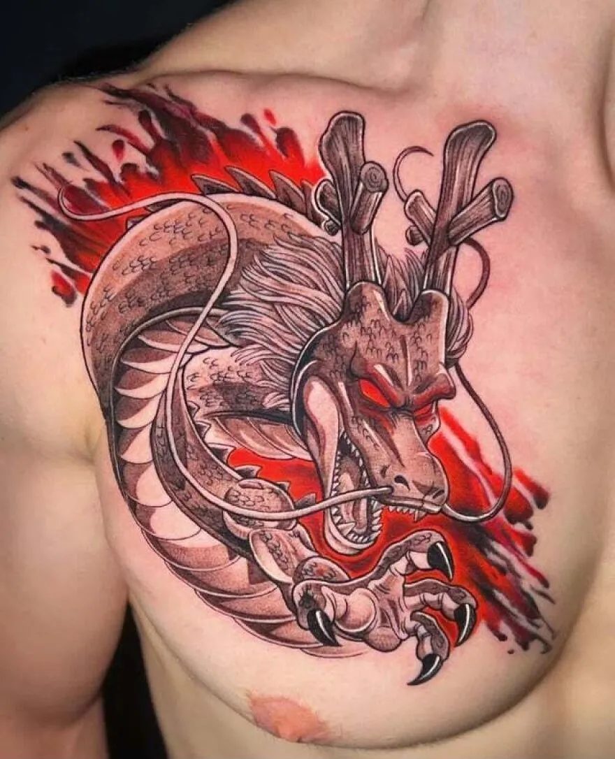 Detailed dragon tattoo on a person's chest with red and black ink accents.