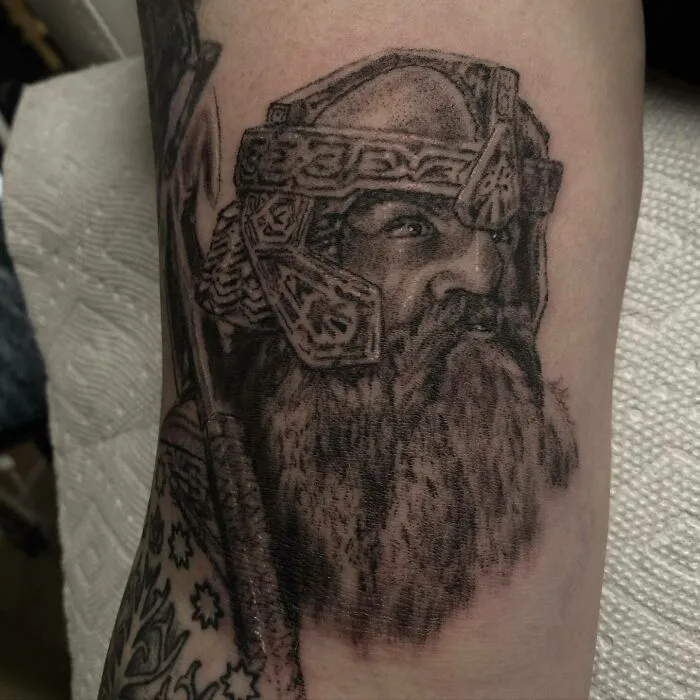 Detailed Lord of the Rings tattoo depicting a helmeted character with a beard on an arm.