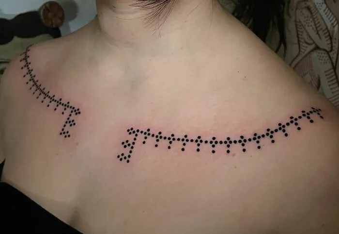 Collarbone tattoos featuring a minimalist dotted design on a woman's shoulders.