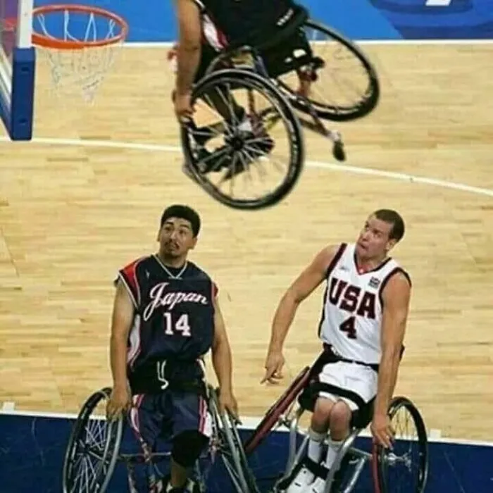 Cursed meme of athletes in wheelchairs playing basketball, a player mid-air upside down.