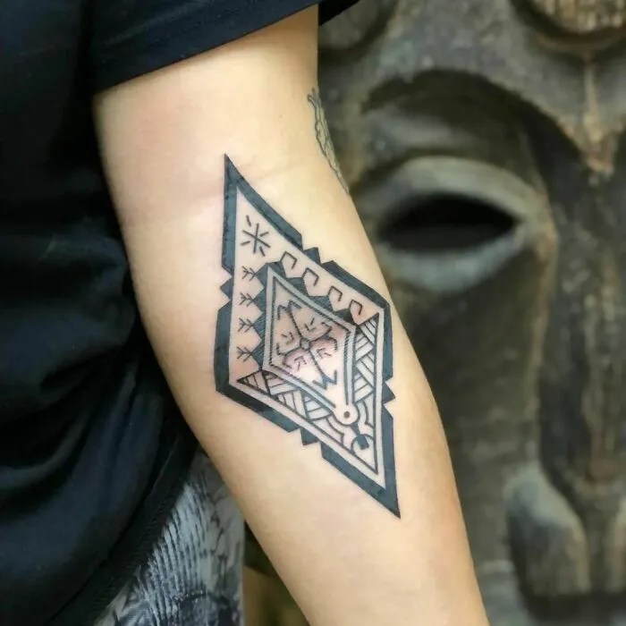 Tribal tattoo with geometric design on the forearm.