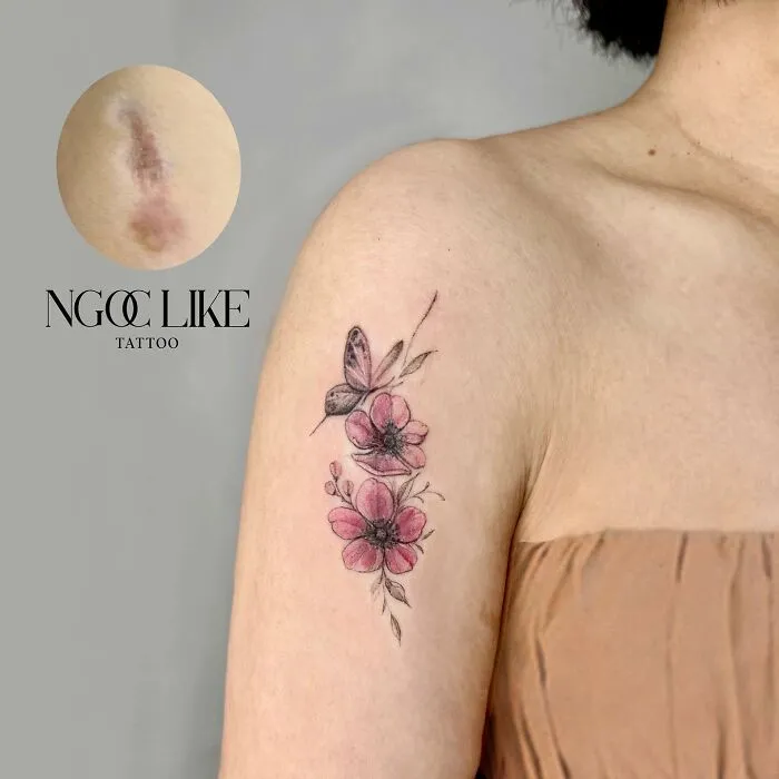 Tattoo artist covers a scar on a woman's arm with a floral butterfly design.