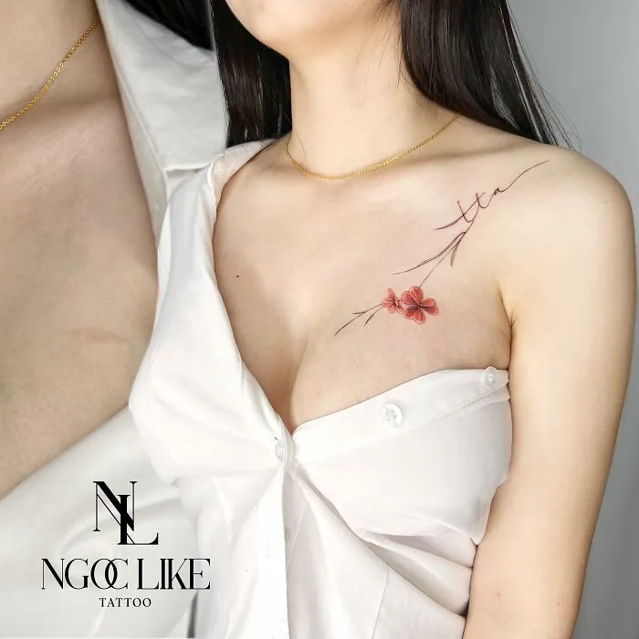 Tattoo covers scar with floral design on woman's shoulder.