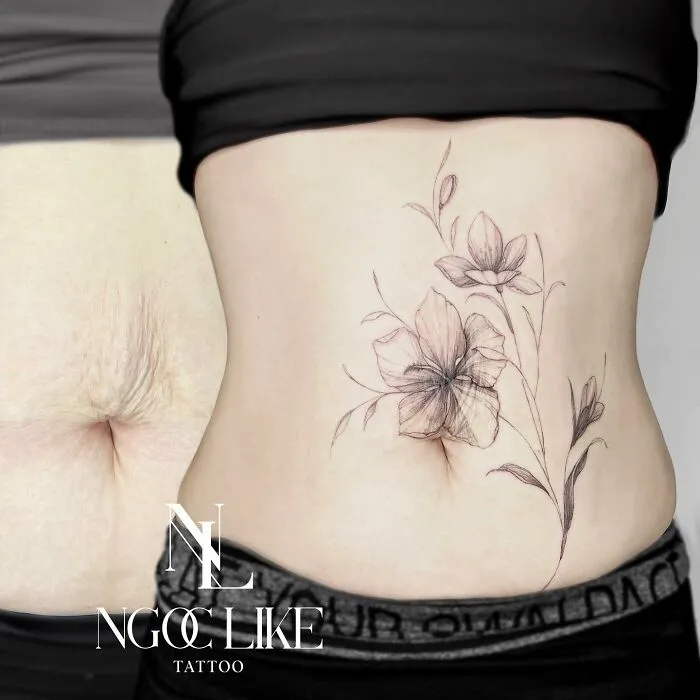 Tattoo artist covers a stomach scar with floral tattoo design, transforming the appearance beautifully.