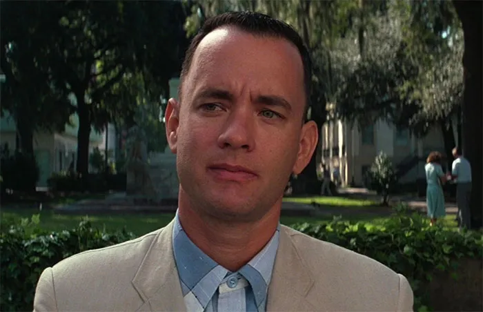 Forrest Gump sitting on a park bench reflecting in a peaceful outdoor setting for Forrest Gump quotes collection