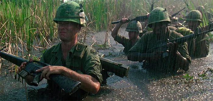 Forrest Gump in military training, carrying a rifle through water, representing key Forrest Gump quotes and scenes.