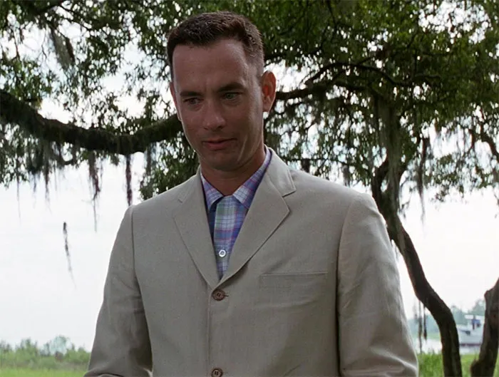 Forrest Gump wearing a beige suit outdoors, representing iconic moments from Forrest Gump quotes collection.