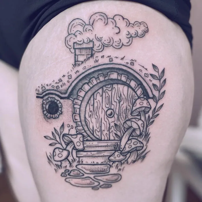Tattoo of a Hobbit house with mushrooms and plants, inspired by Lord of the Rings.