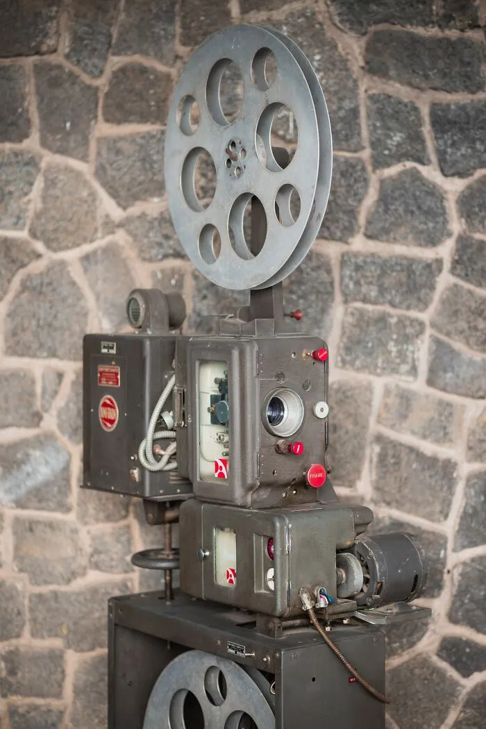 Old Film Projector Standing Near A Wall 