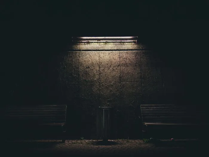 Trash Bin And Couple Of Benches On A Light In A Night 