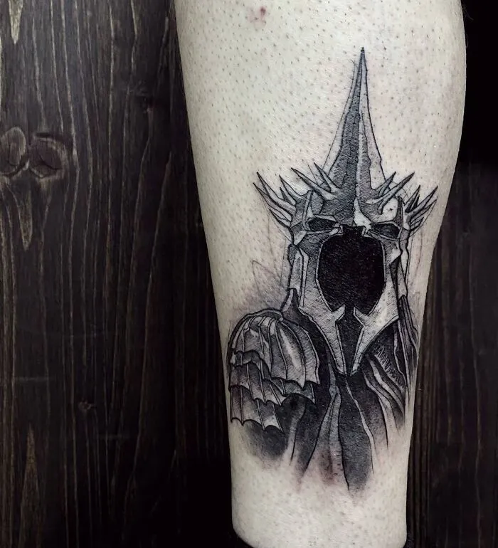 Arm tattoo of a detailed black and gray Sauron helmet from Lord of the Rings.