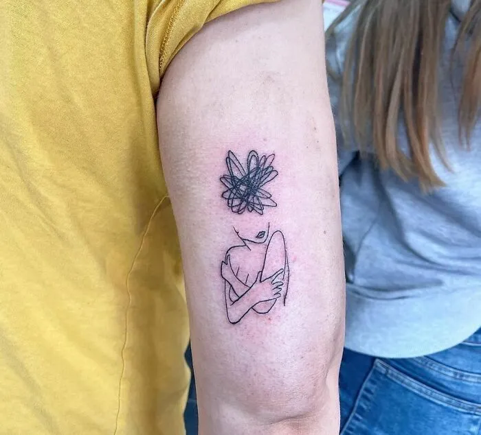 Line art mental health tattoo on forearm, depicting a person holding themselves, with a chaotic scribble above their head.