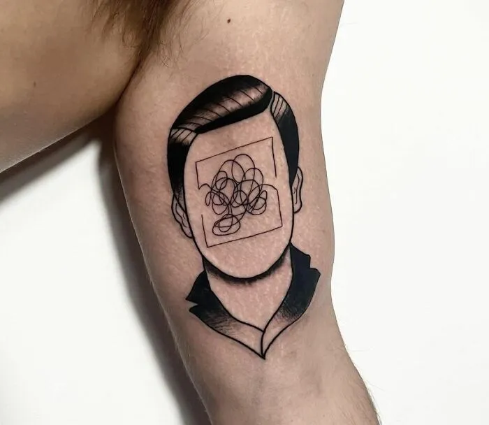 Tattoo of a faceless person with a scribble on the face, symbolizing mental health struggles.
