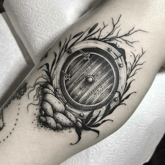 Tattoo design of a round door inspired by Lord of the Rings on an arm.