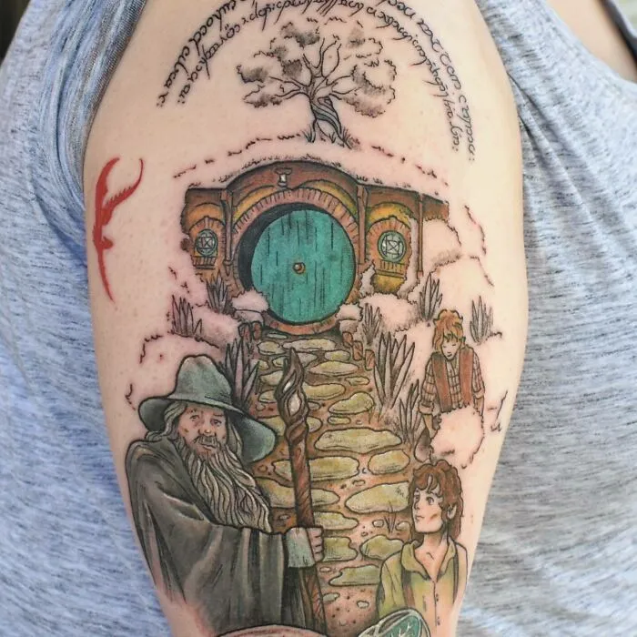 Lord of the Rings tattoo featuring characters and iconic Shire door on arm.