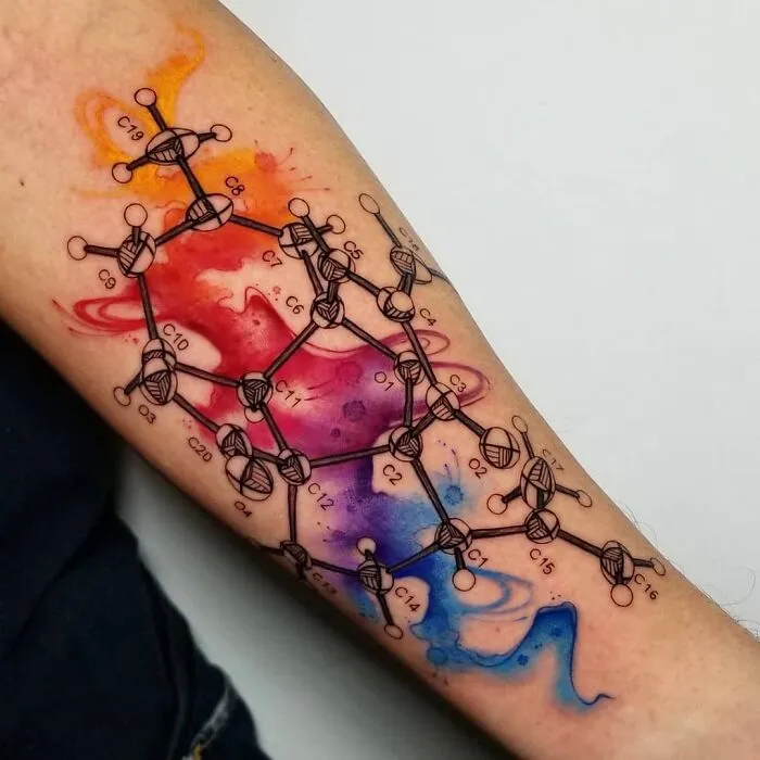 Colorful molecular structure tattoo on arm, showcasing science-themed art.