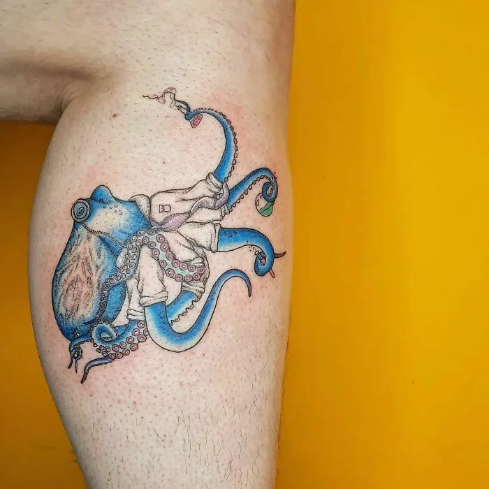 Colorful octopus tattoo on leg, blending science and art with vibrant blue and pink hues.