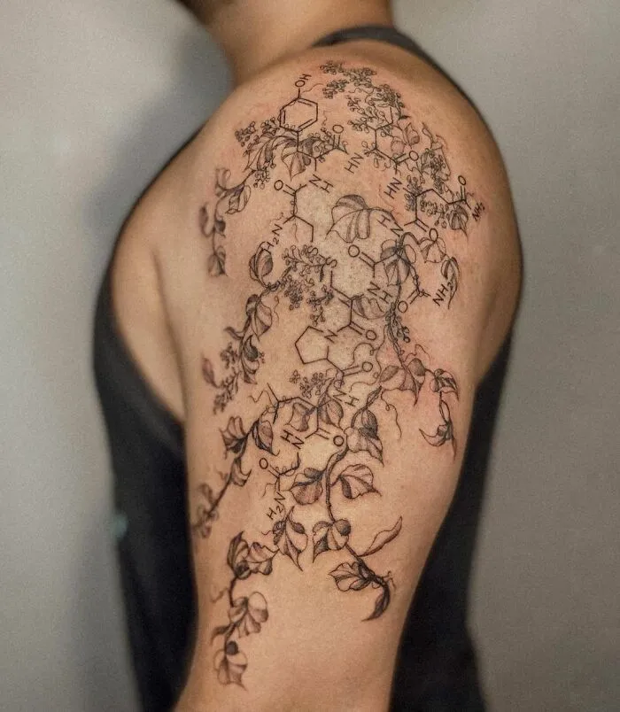 Science tattoo with molecular structures and botanical elements on a person's upper arm.