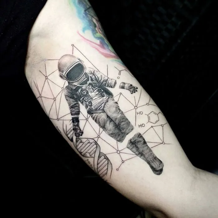 Science tattoo featuring DNA, chemical structure, and an astronaut on an arm.