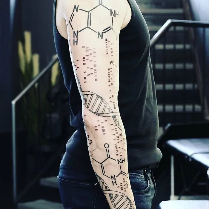 A forearm with science tattoos, featuring DNA and molecular structures, symbolizing scientific passion and creativity.