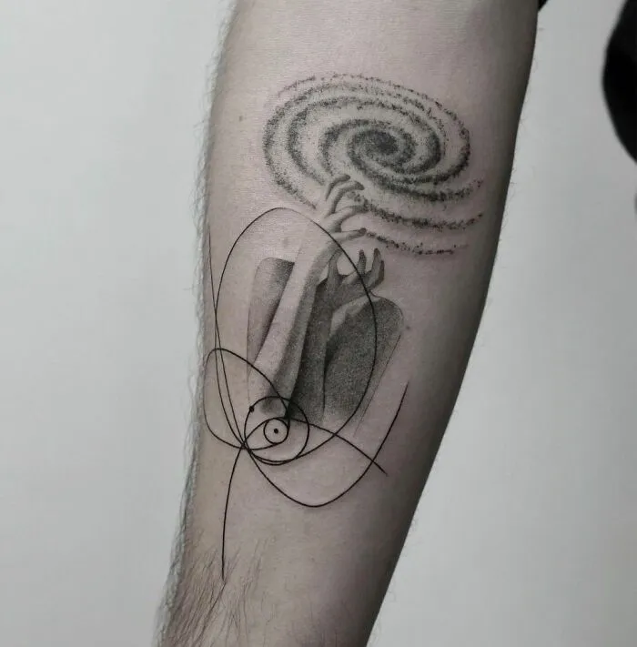 Abstract mental health tattoo featuring hands holding a swirling galaxy on an arm, symbolizing healing and inner peace.