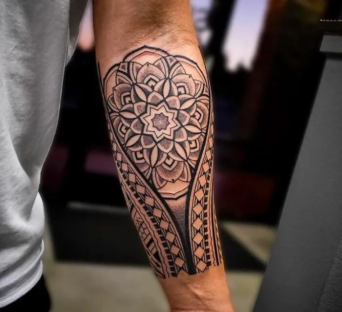 Intricate tribal tattoo design on a forearm, showcasing bold patterns and symmetry.