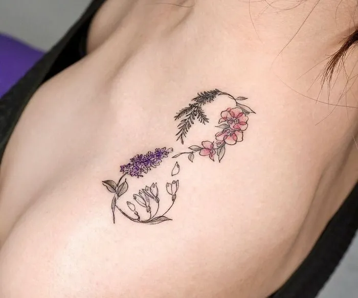 Floral infinity tattoo on shoulder, showcasing creativity with colorful flowers and leaves.
