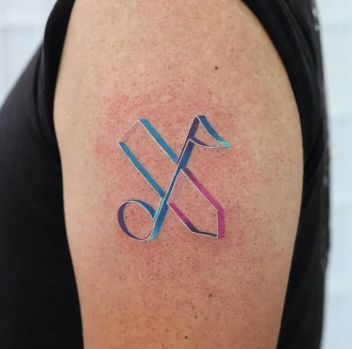 Colorful music tattoo on upper arm, featuring abstract notes in shades of blue and purple.