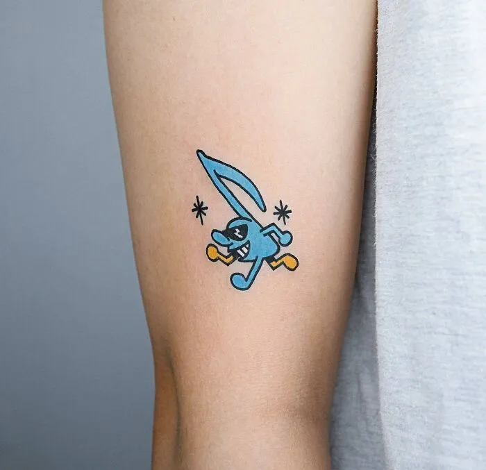 Colorful cartoon character music tattoo on arm.
