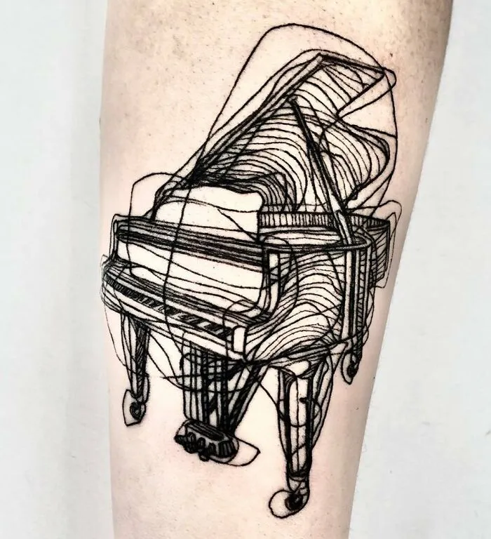 Tattoo of a grand piano line drawing on forearm, showcasing a unique music tattoo design.