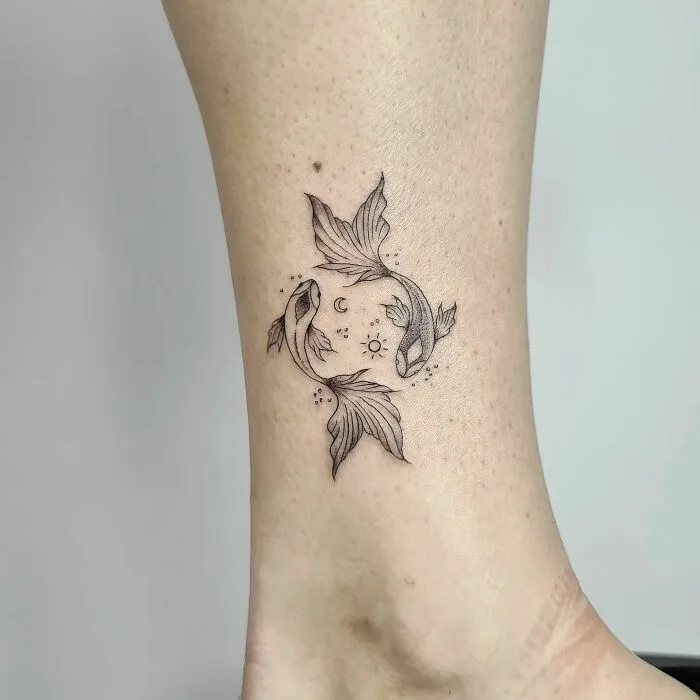 Yin Yang tattoo with koi fish on ankle, symbolizing duality and balance.