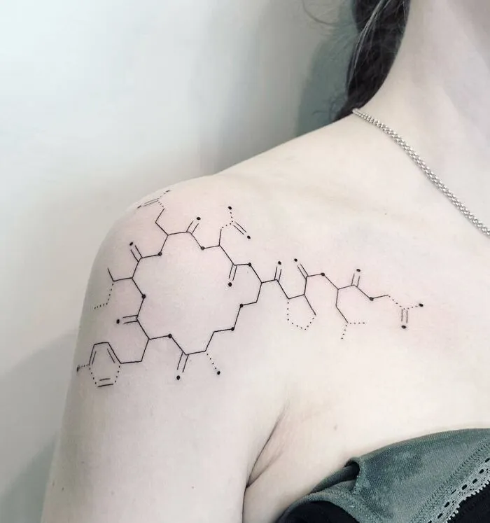 Science tattoo of a chemical structure inked on a woman's shoulder.