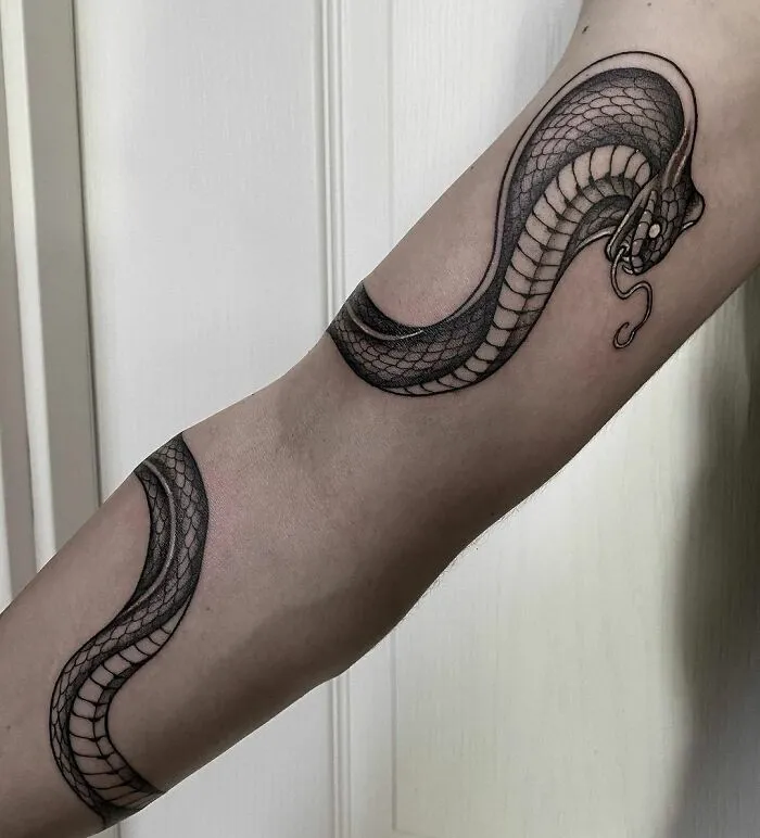 Snake tattoo design wrapping around arm with detailed scales.