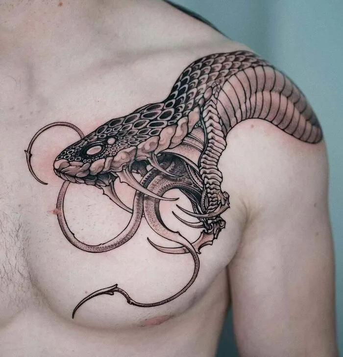 Snake tattoo on upper chest, detailed design wrapping around shoulder and collarbone.