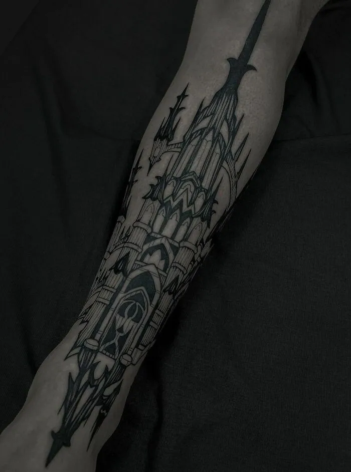Gothic tattoo of a detailed cathedral design on forearm, showcasing intricate black ink artistry.