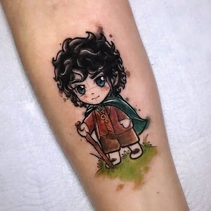 Chibi-style Lord of the Rings tattoo featuring a character with curly hair and a green cloak.