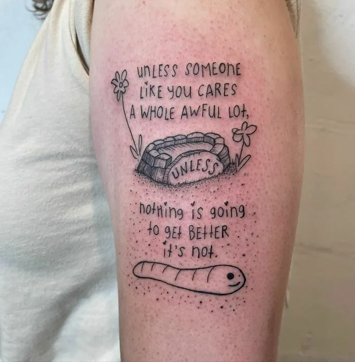 Arm tattoo featuring a meaningful quote with flowers and a caterpillar, focusing on mental health and healing themes.