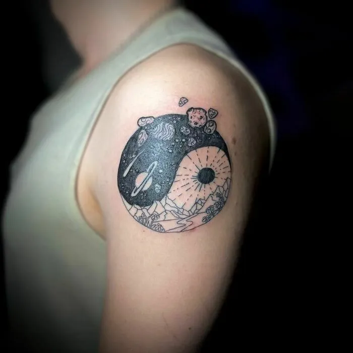 Yin Yang tattoo on arm, featuring cosmic and nature patterns, symbolizing life's duality.