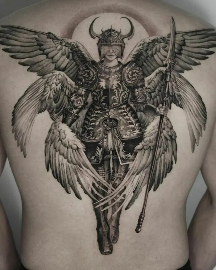 Gothic tattoo of a winged warrior in detailed armor covering a person's back.