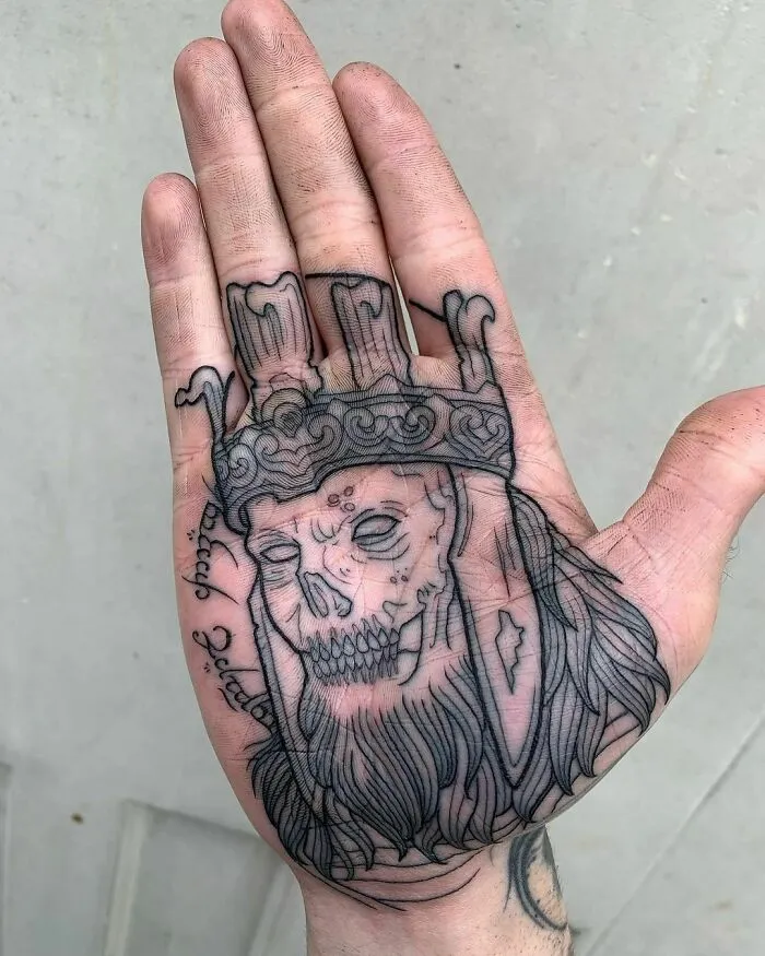 Lord of the Rings tattoo depicting a skeletal king with a crown inked on a person's palm.