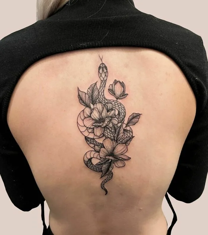 Snake tattoo design on a person's back, featuring intricate floral details.
