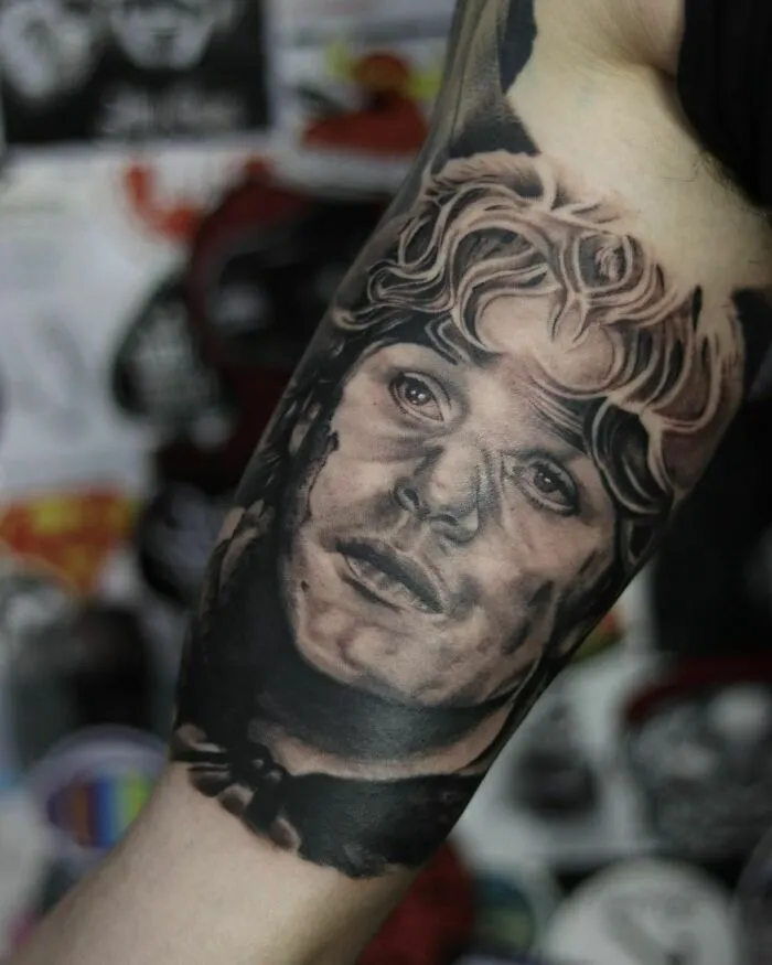 Realistic Lord of the Rings tattoo of a character's face on a person's forearm, showcasing intricate details.