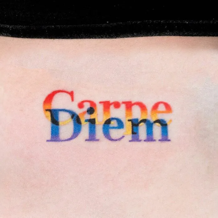 Colorful "Carpe Diem" tattoo with a rainbow gradient, symbolizing healing and mental health empowerment.