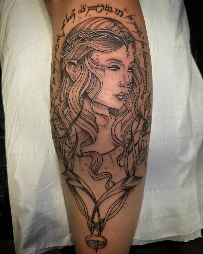 Lord of the Rings tattoo featuring an elf portrait surrounded by Elvish script on a person's leg.