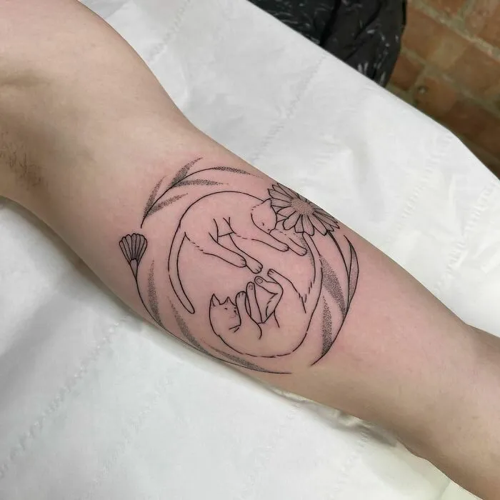 Yin Yang tattoo design featuring two cats intertwined with floral elements.